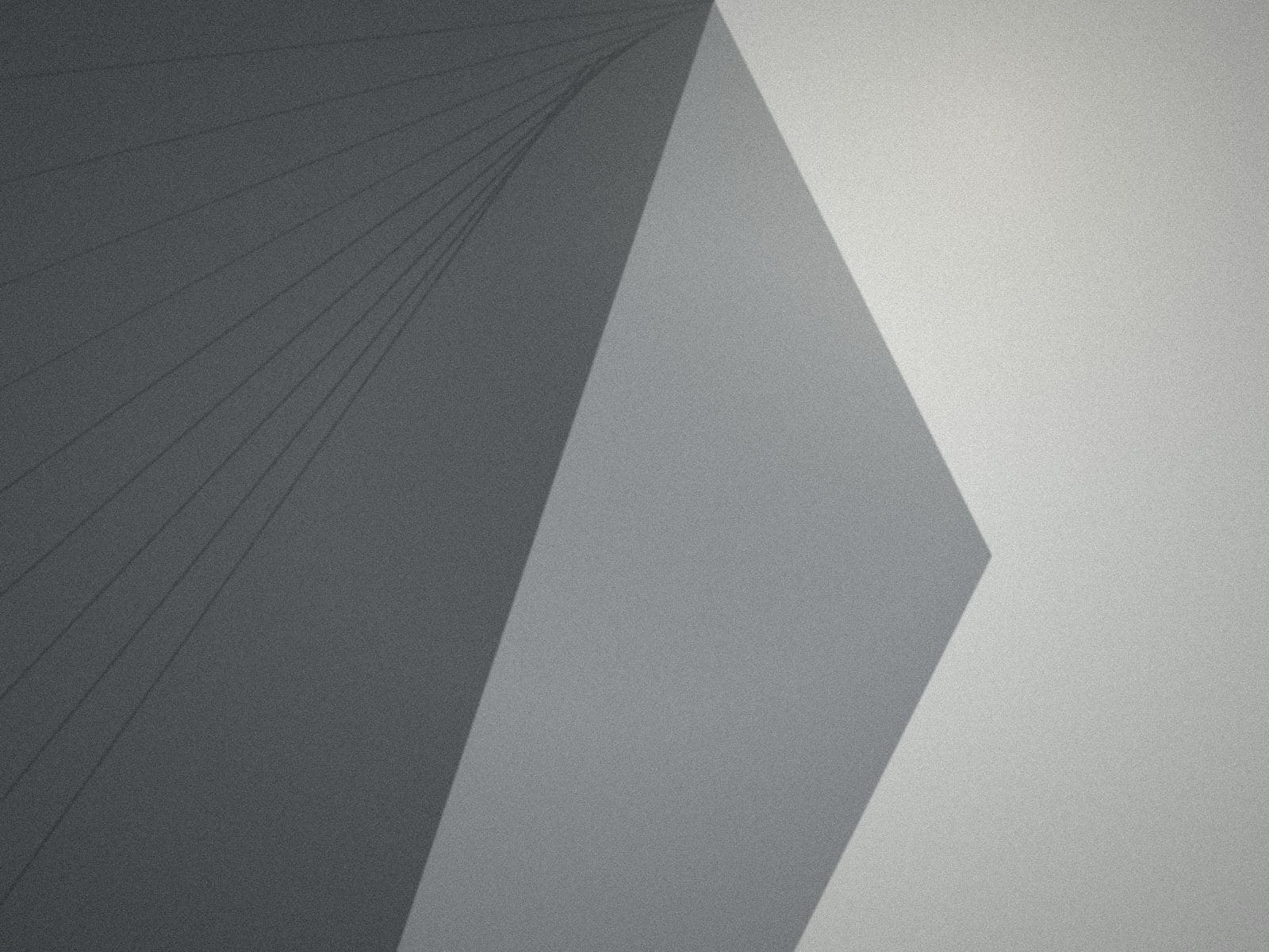 A concrete wall cut by a hard diagonal shadow