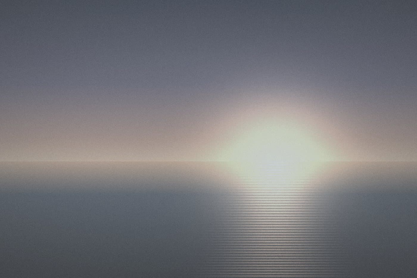 A pale sun low over a calm sea under a grey sky, before editing