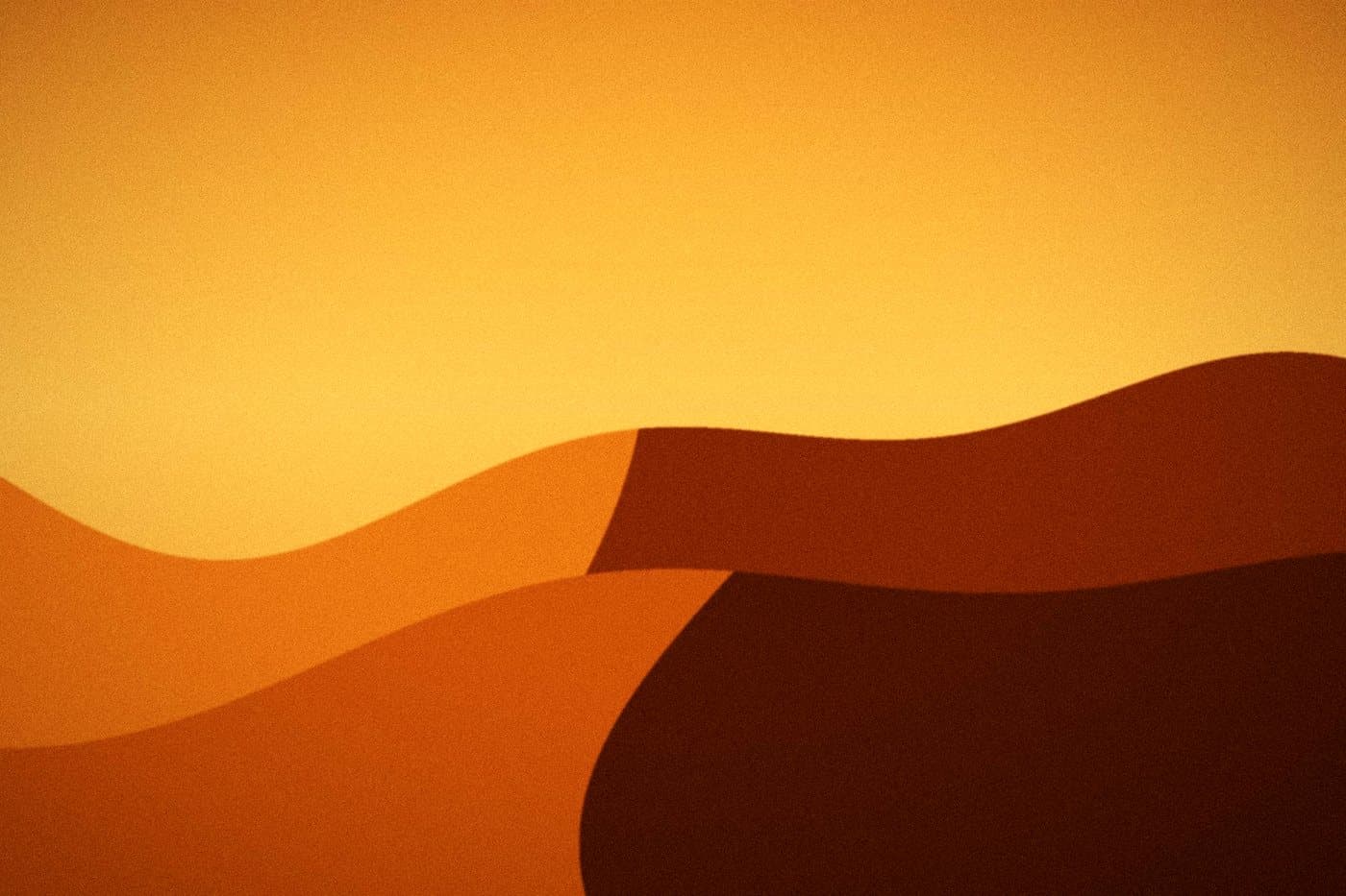 The same dunes after Golden Hour: an amber sky and glowing orange sand with deep shadow on the slopes