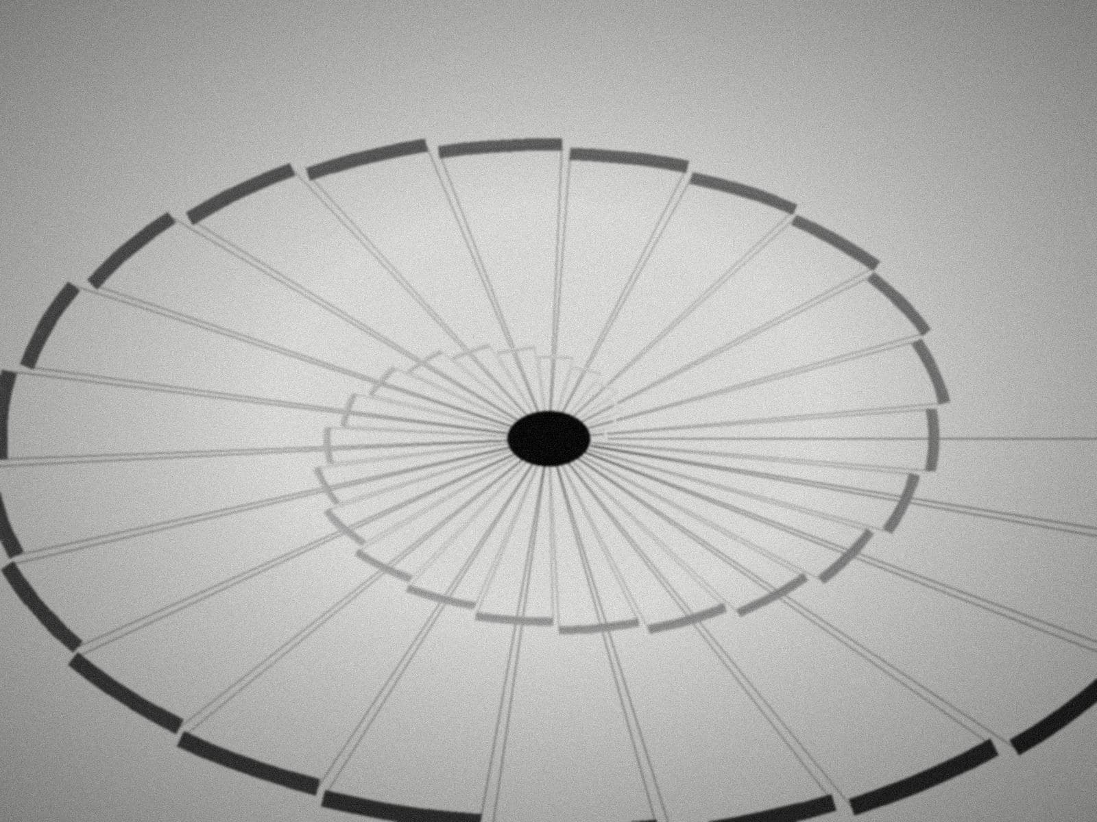 A spiral stairwell seen from above in black and white
